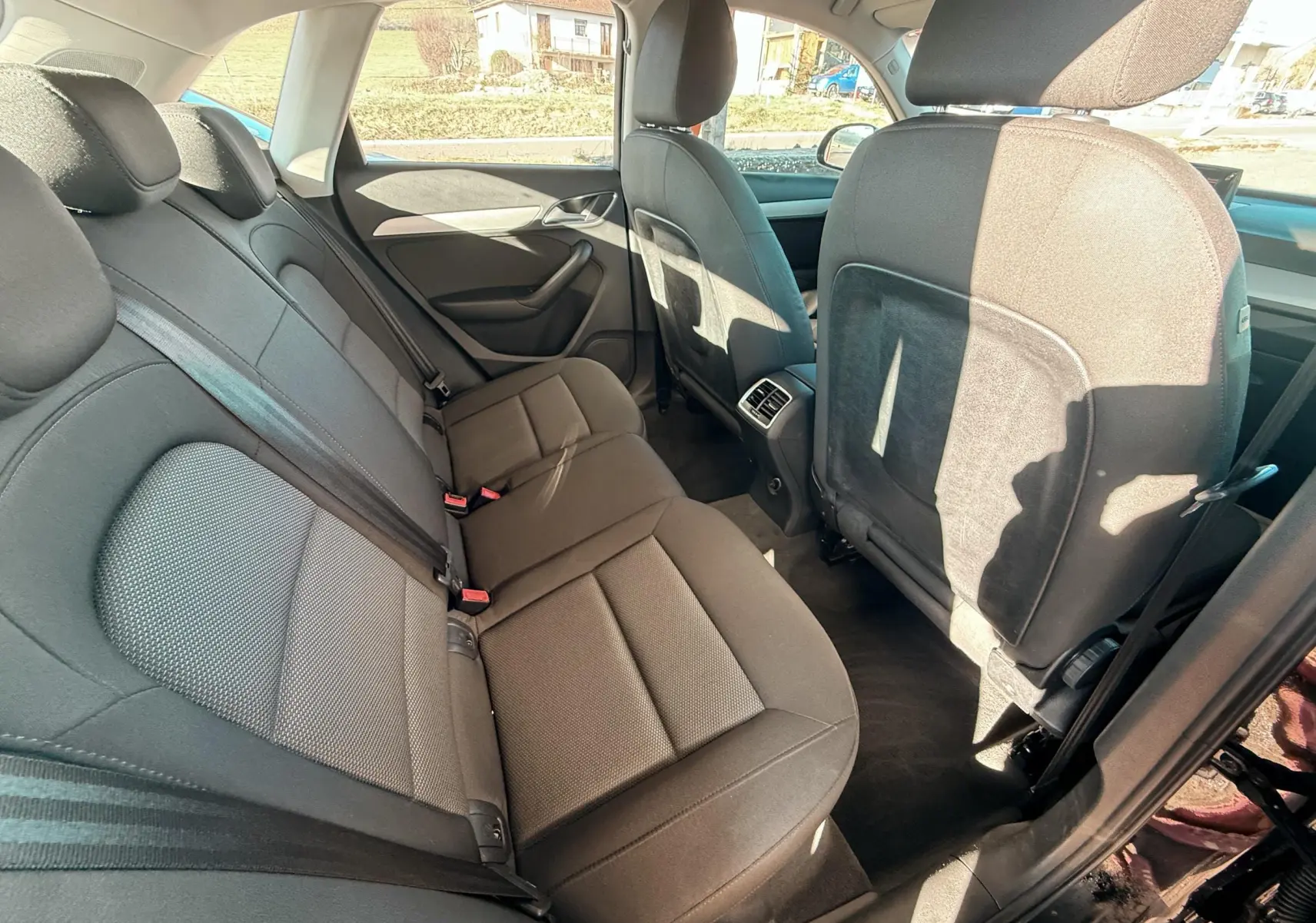 Vue intérieure arrière côté droit montrant les sièges en tissu noir de l'Audi Q3 2016.