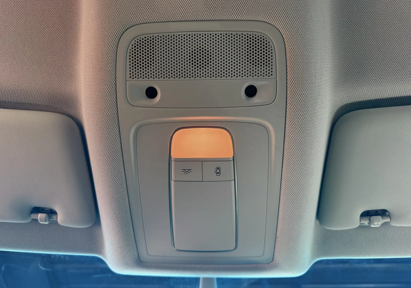 Plafonnier intérieur allumé vu de dessous dans l'Audi Q3 noir, avec boutons de commande et pare-soleil visibles.