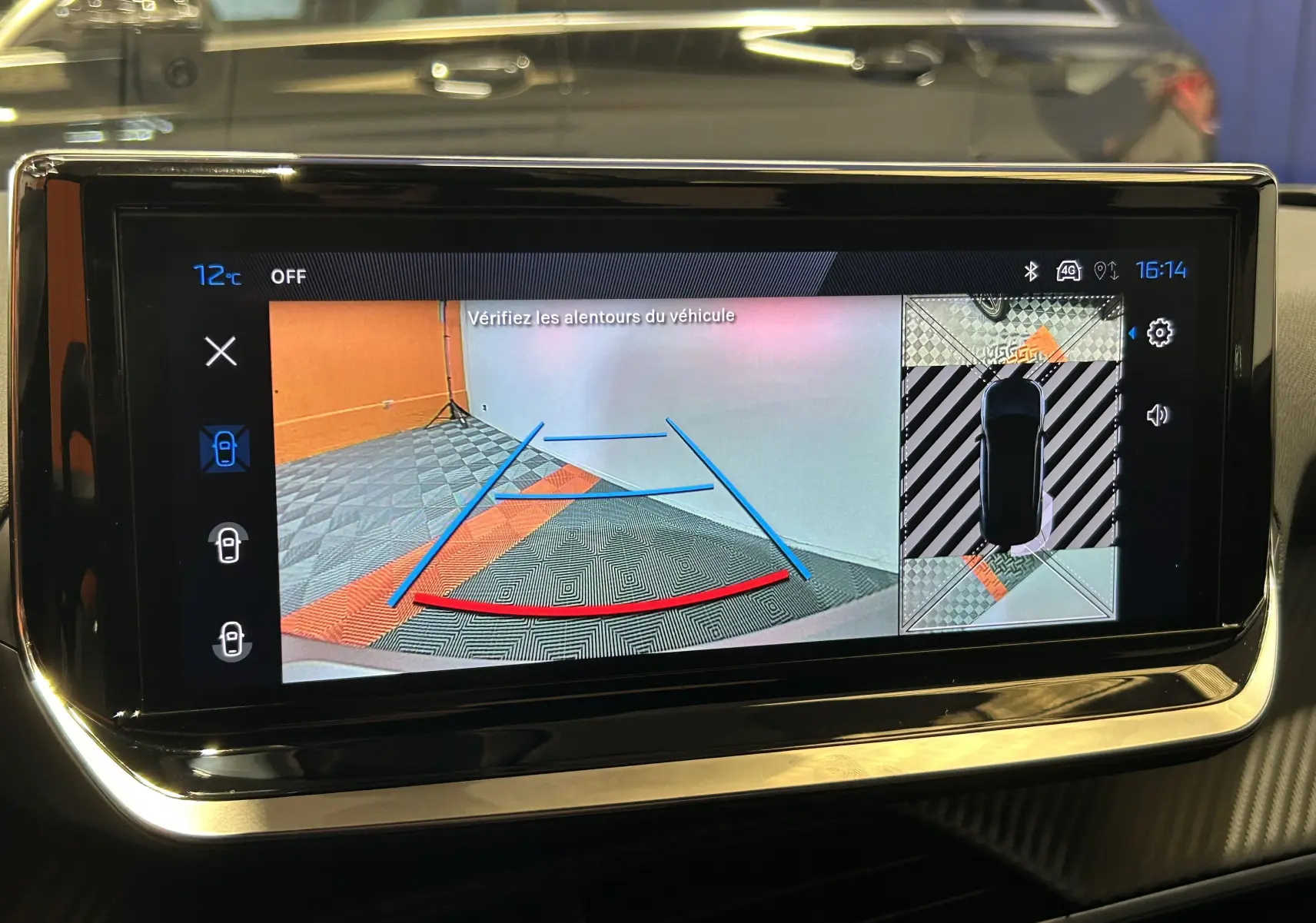 Écran tactile intérieur de la Peugeot 2008 bleu Obsession montrant la caméra de recul et la vue à 360° en stationnement.