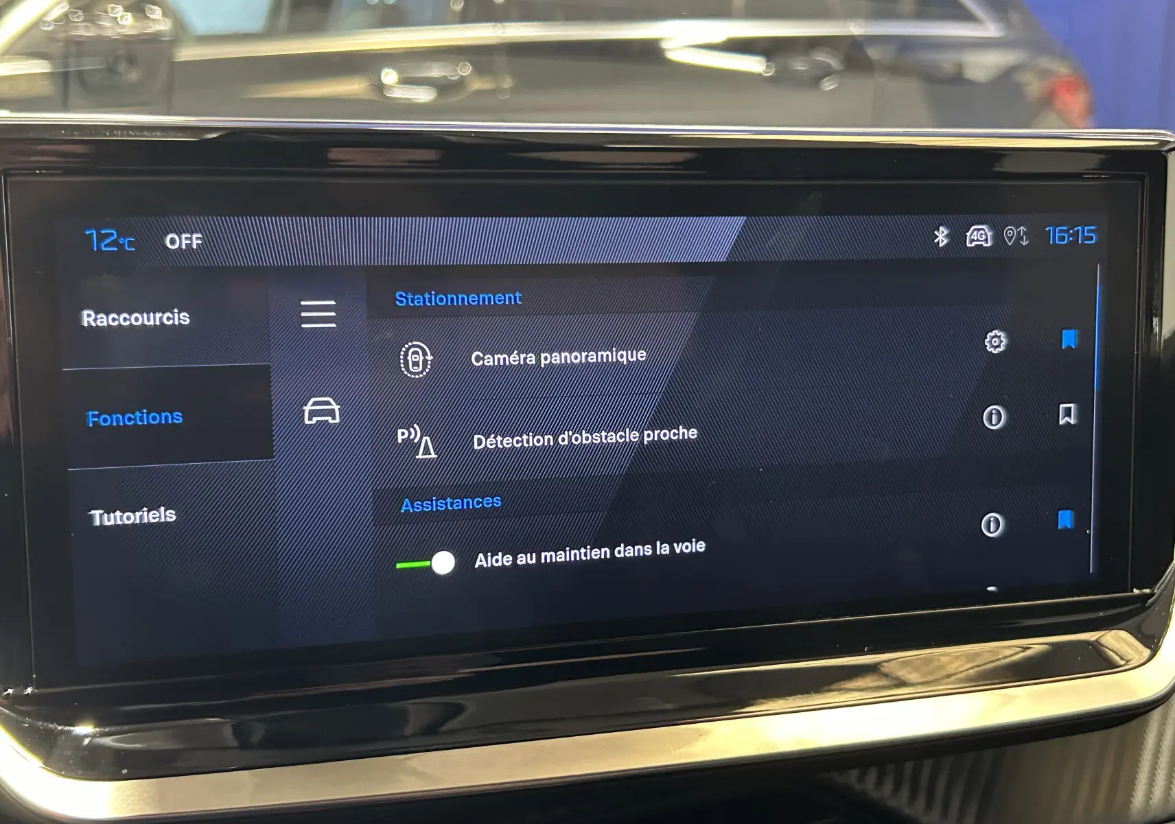 Écran tactile central du Peugeot 2008 bleu Obsession montrant les options d'assistance à la conduite et caméra panoramique.