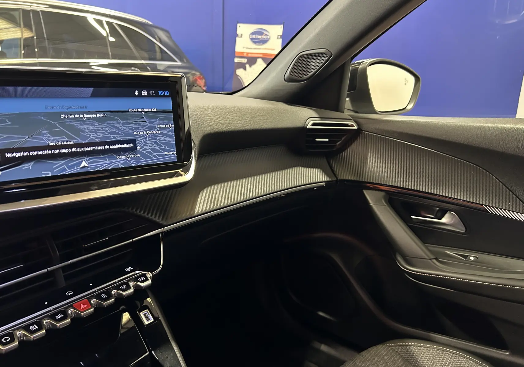Vue intérieure côté passager du Peugeot 2008 II Ph.2 Allure Hybrid 145 avec écran tactile et finition carbone.