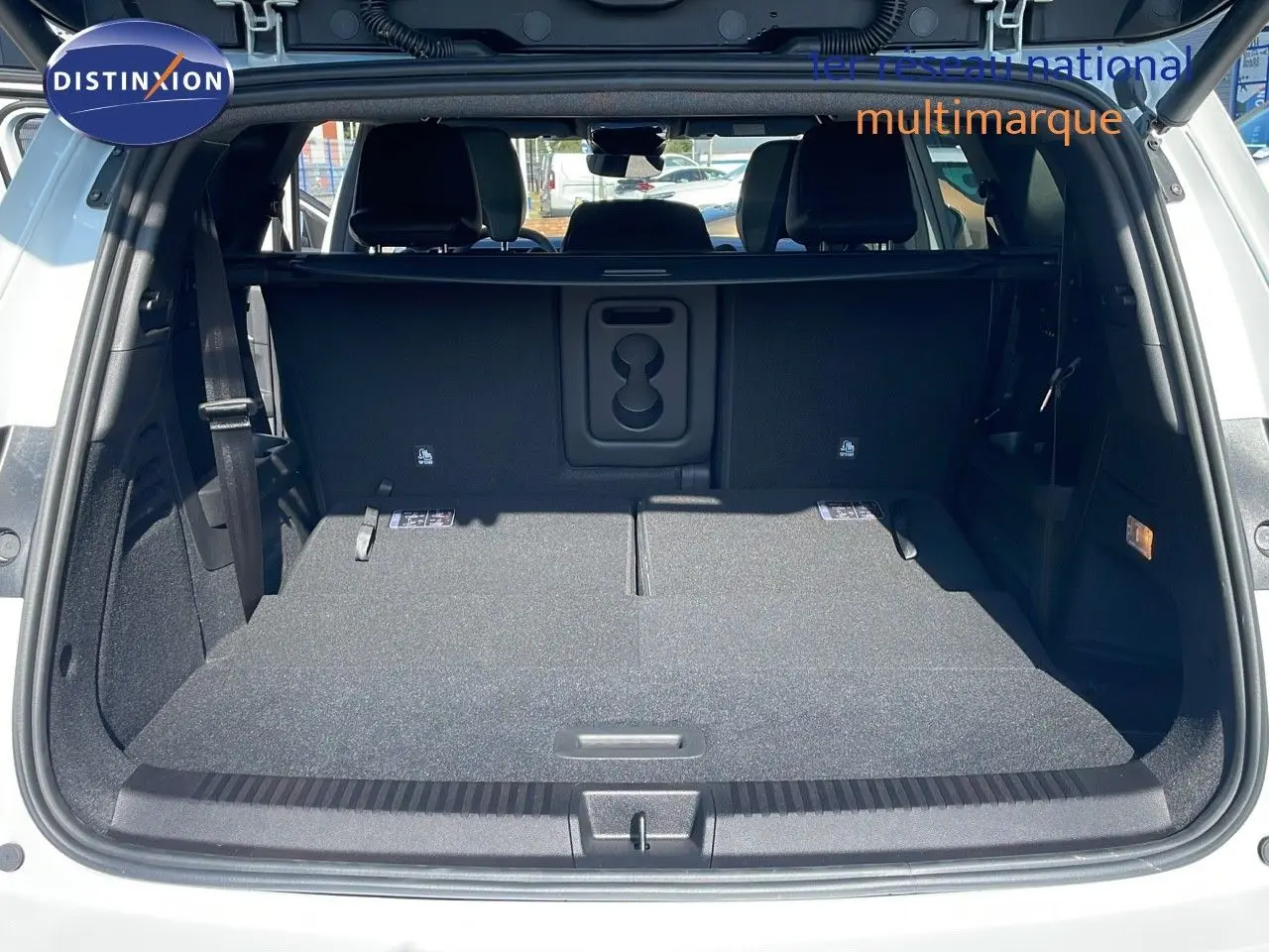 Coffre ouvert d'un Renault Espace blanc nacré 2025, vue arrière montrant l'espace de chargement avec sièges rabattus.