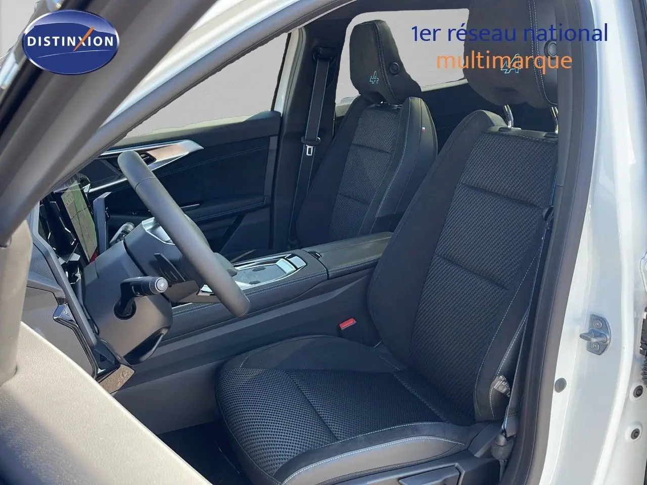 Vue intérieure côté conducteur du Renault Espace 2025 blanc nacré, sièges noirs avec logo Alpine brodé sur les appuie-têtes.