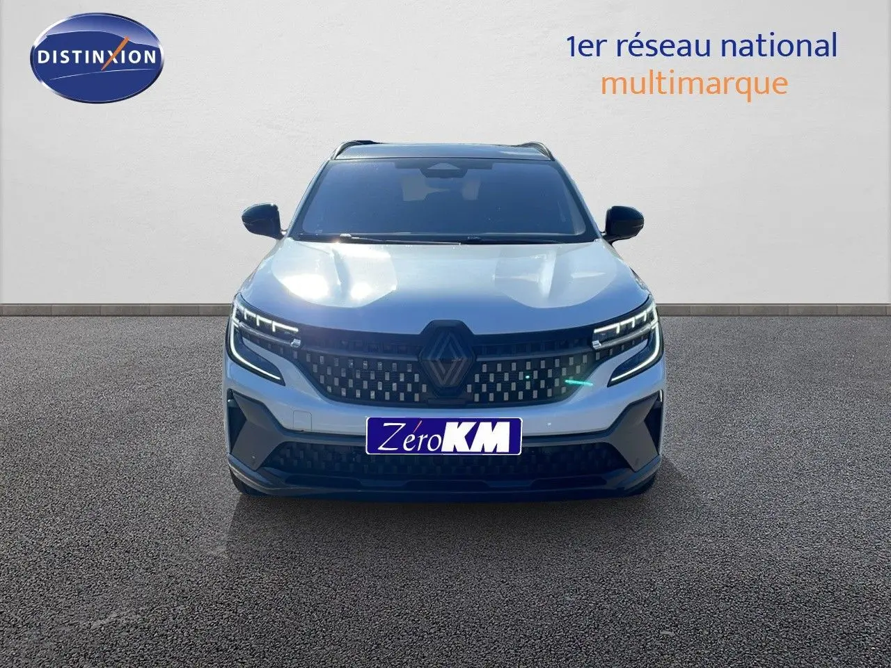 Vue frontale d'un Renault Espace blanc nacré 2025 avec calandre noire et feux LED distinctifs allumés.