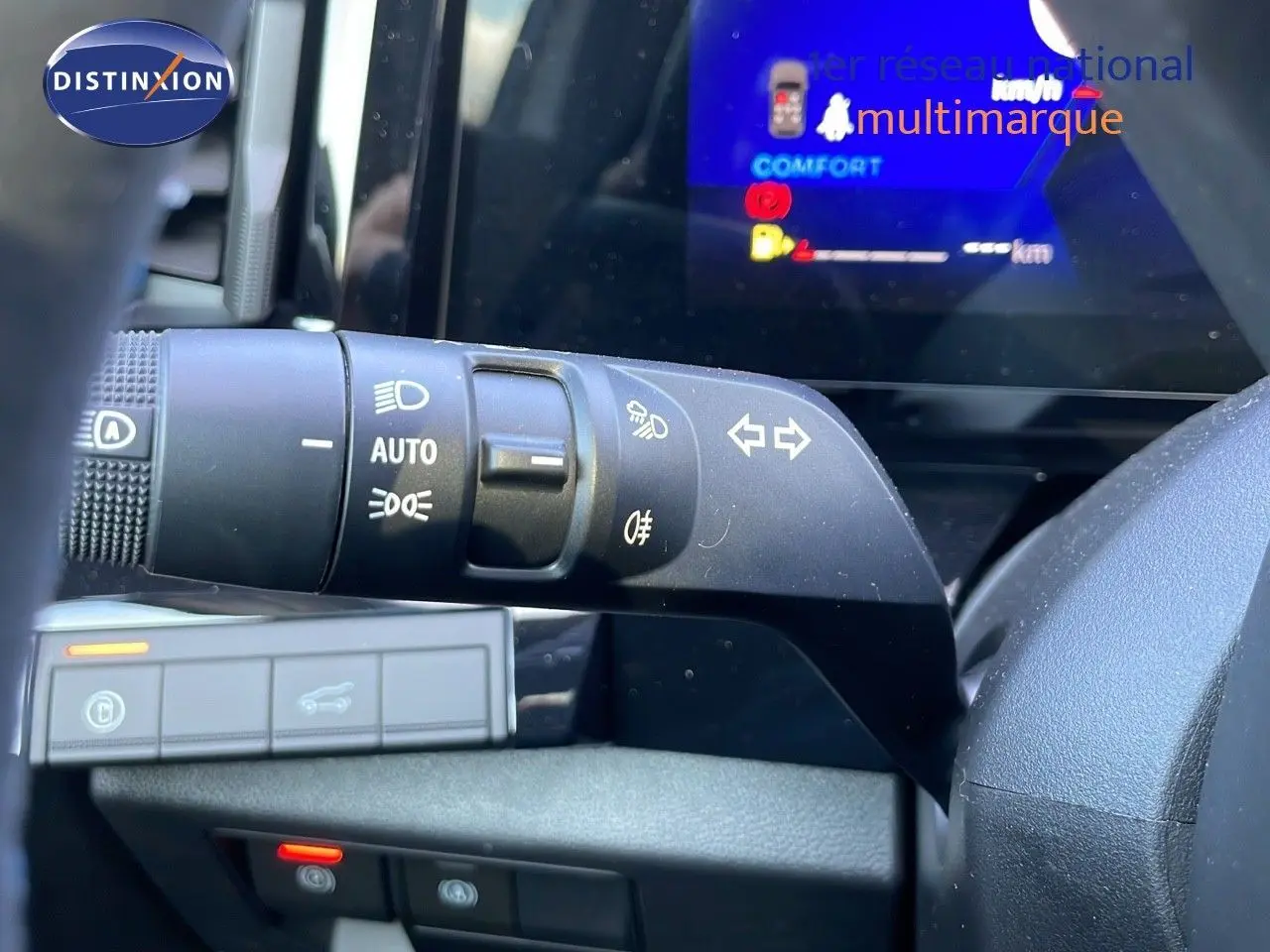 Gros plan sur la commande des feux et clignotants à gauche du volant dans l'habitacle du Renault Espace blanc nacré 2025.