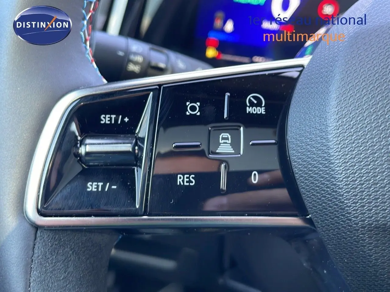 Gros plan sur les commandes de régulateur de vitesse au volant du Renault Espace blanc nacré 2025 hybride.