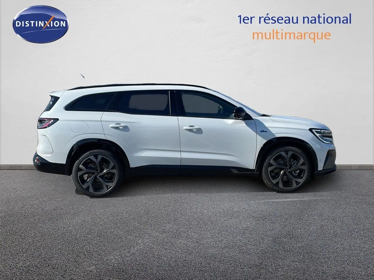 Profil côté droit du Renault Espace 2025 blanc nacré, SUV hybride avec jantes noires et toit panoramique.