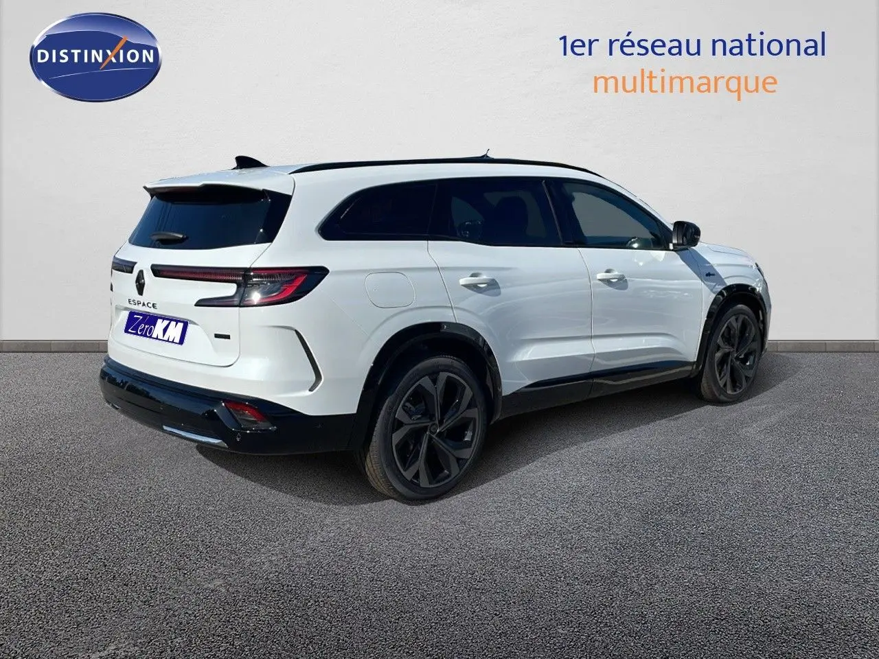 Vue 3/4 arrière droite d'un Renault Espace blanc nacré 2025 avec jantes noires et feux arrière LED allumés.