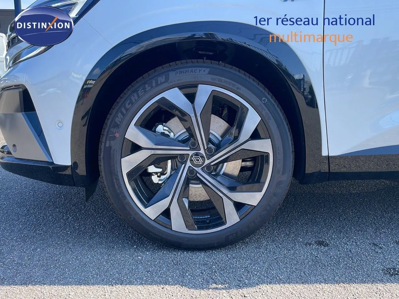 Gros plan sur la roue avant gauche du Renault Espace blanc nacré 2025, mettant en valeur la jante alliage bicolore moderne.