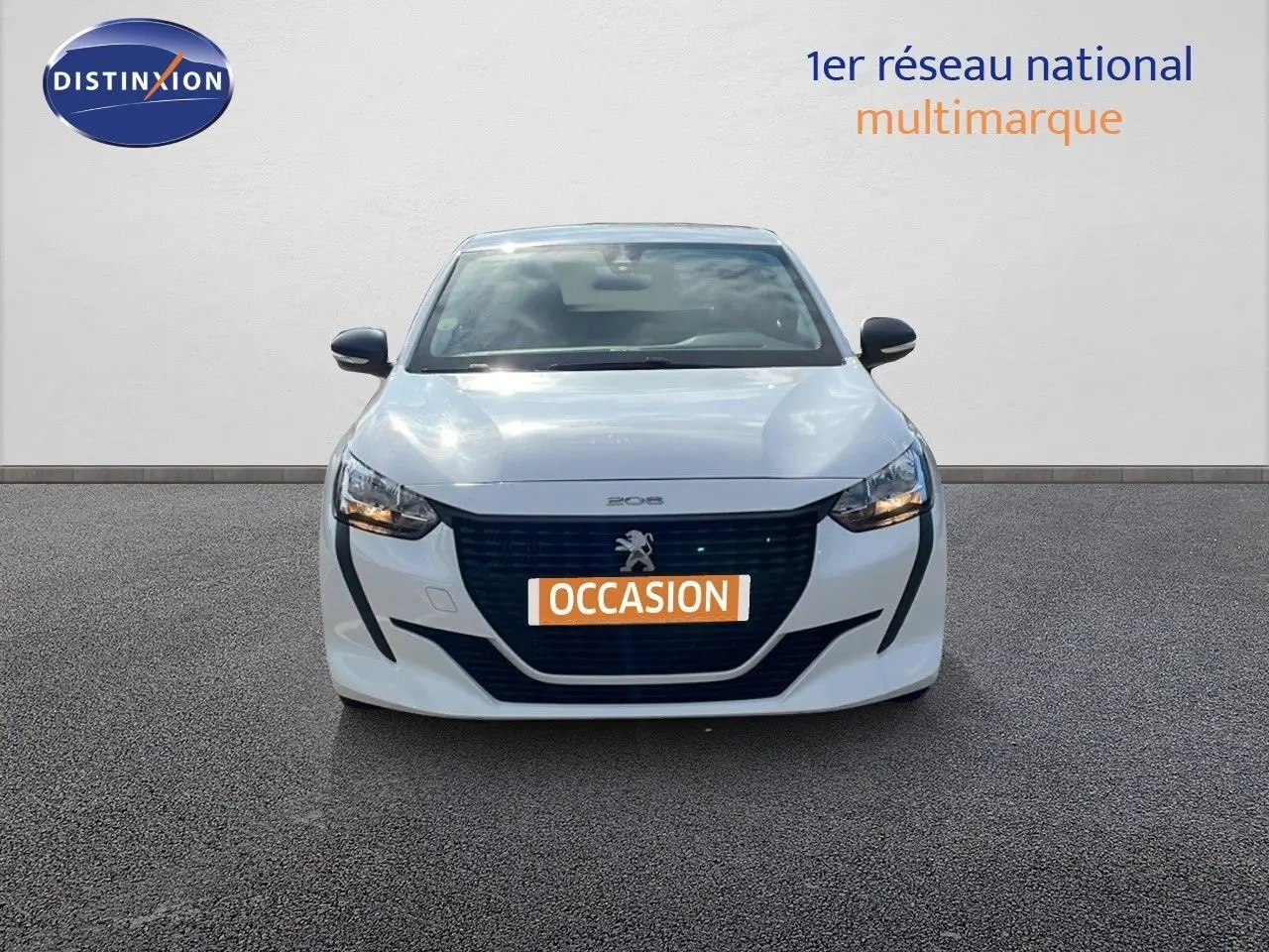 Vue frontale d'une Peugeot 208 blanche banquise avec calandre noire et plaque "OCCASION" orange visible.