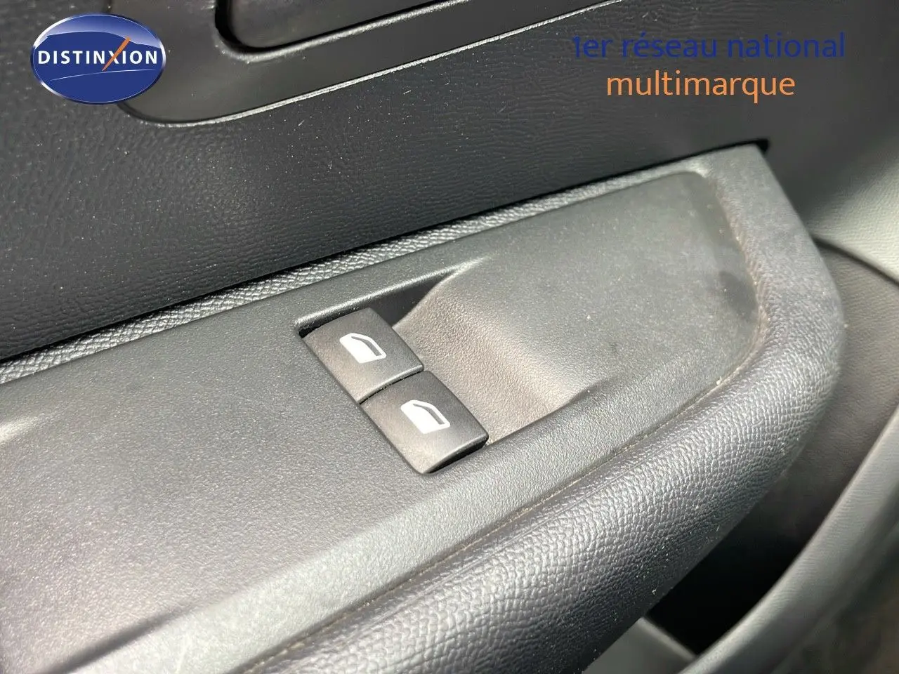 Gros plan sur les commandes des vitres électriques côté conducteur d'une Peugeot 208 blanche banquise 2021.