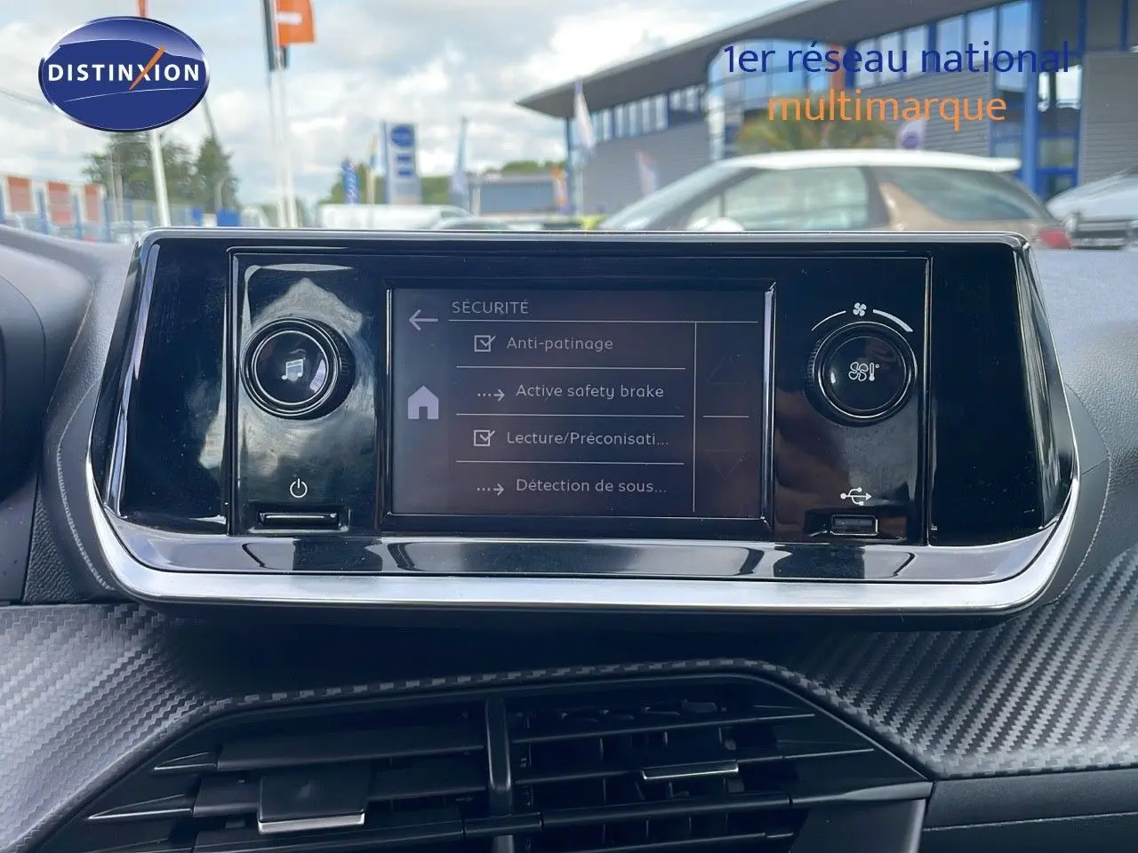 Écran tactile central de la Peugeot 208 blanc banquise 2021 affichant les options de sécurité du véhicule.