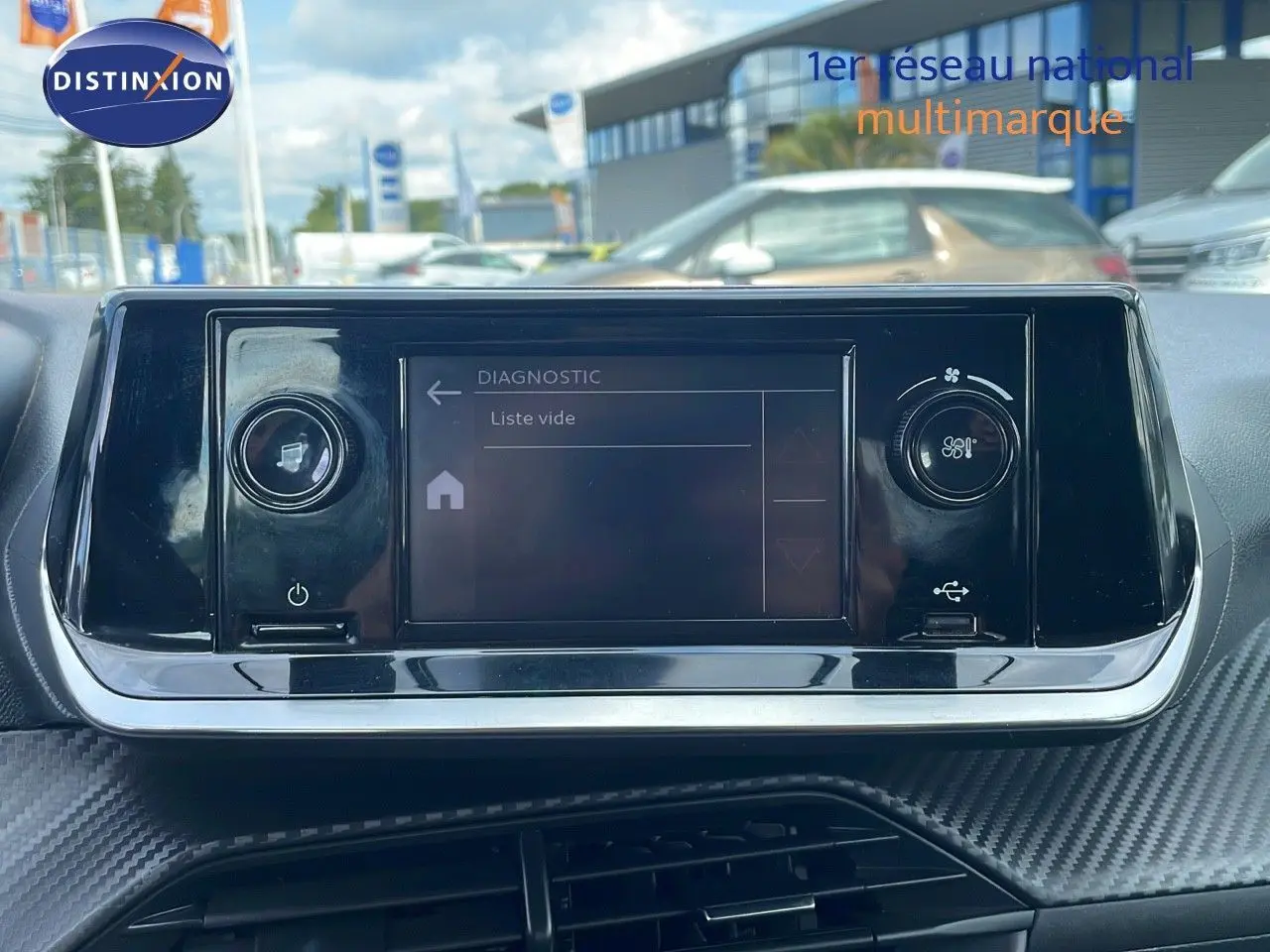 Écran tactile central du tableau de bord de la Peugeot 208 blanc banquise, avec commandes de climatisation visibles.