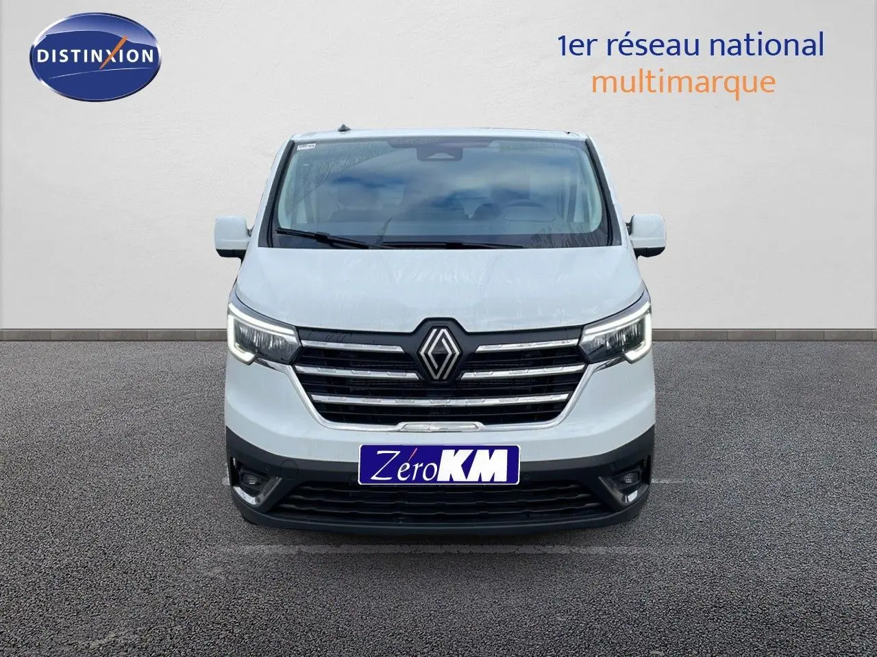 Vue de face d'un Renault Trafic Fourgon blanc glacier avec calandre noire et phares LED allumés.