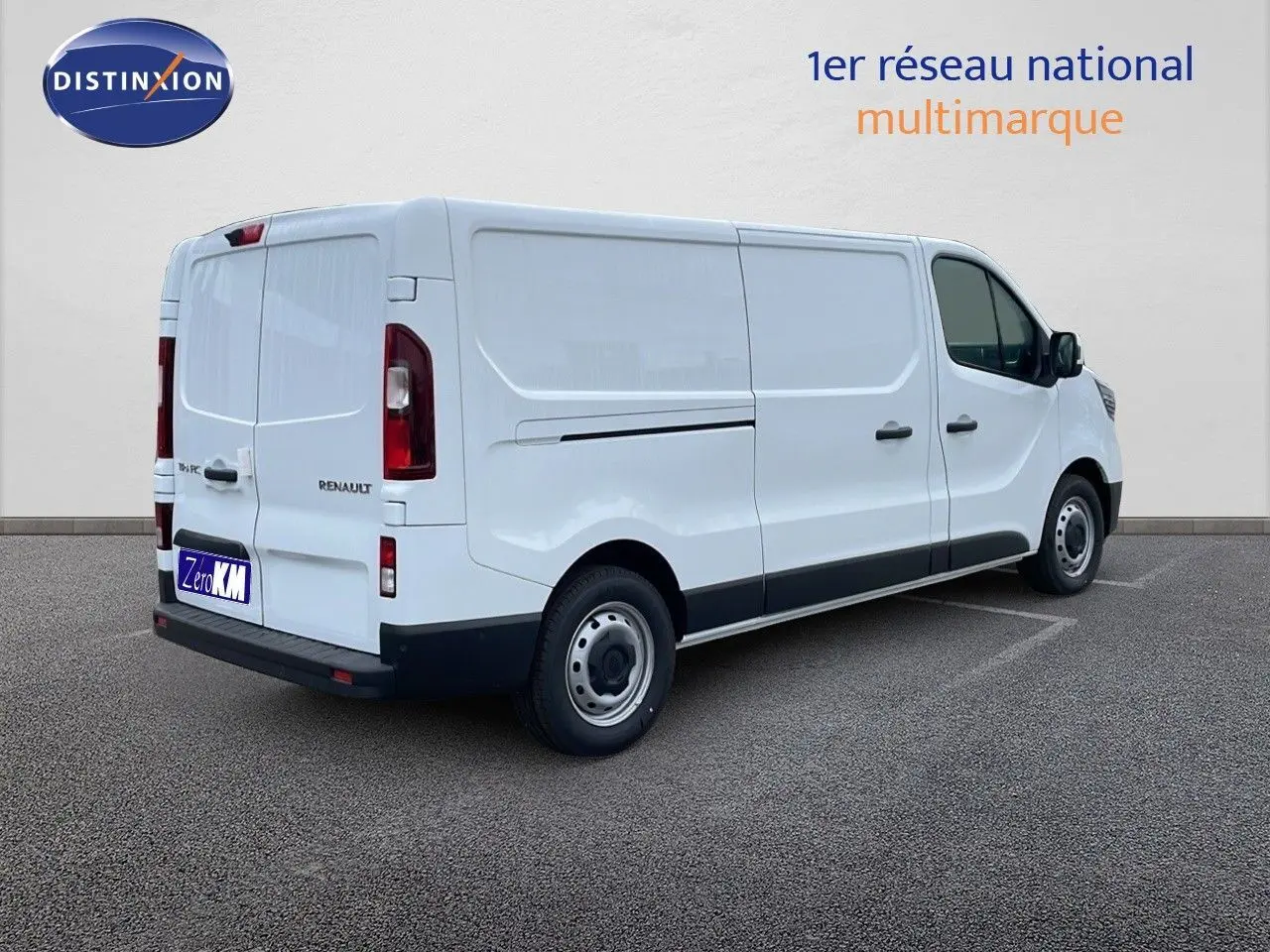 Renault Trafic Fourgon blanc glacier vu en 3/4 arrière côté droit, avec portes latérales et feux arrière visibles.