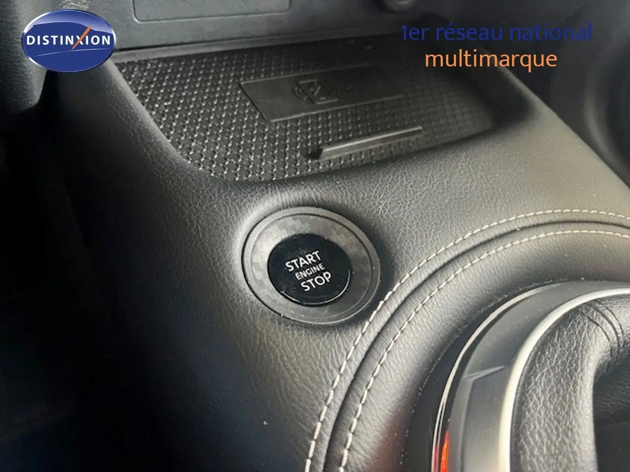 Bouton start/stop moteur en gros plan sur la console centrale en cuir noir du Nissan Juke 2025.