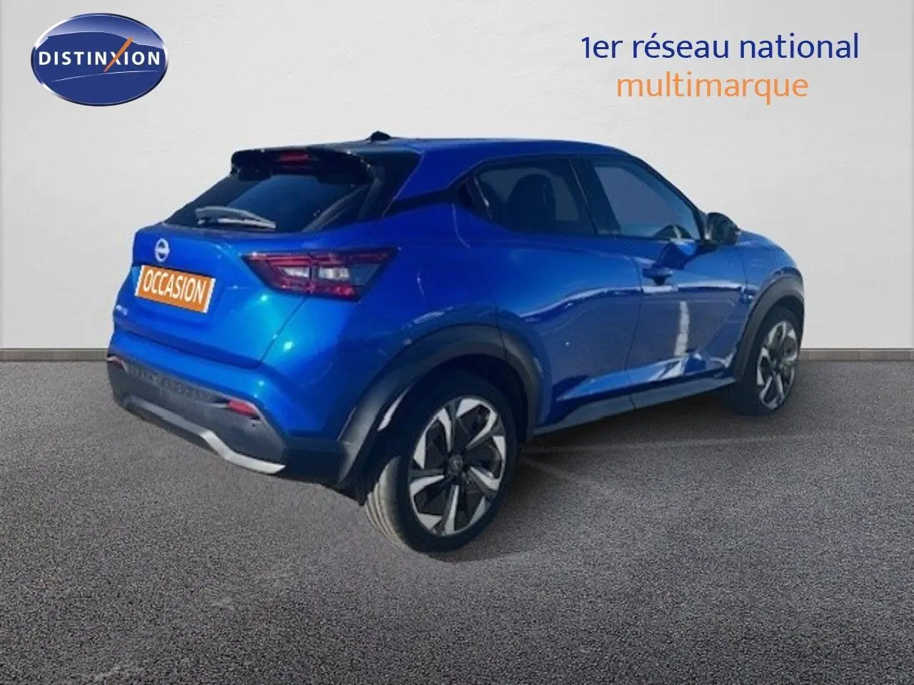 Nissan Juke bleu magnétique 2025 en 3/4 arrière droit, avec jantes alliage et feux arrière LED distinctifs.