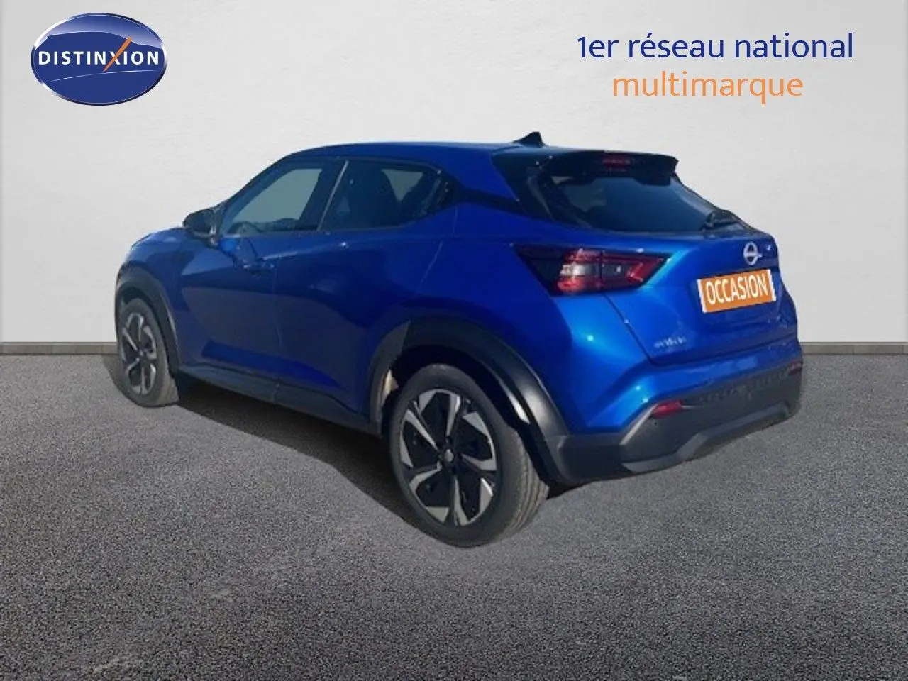 Nissan Juke bleu magnétique métal vu en 3/4 arrière côté gauche, avec jantes noires et détails noirs contrastants.