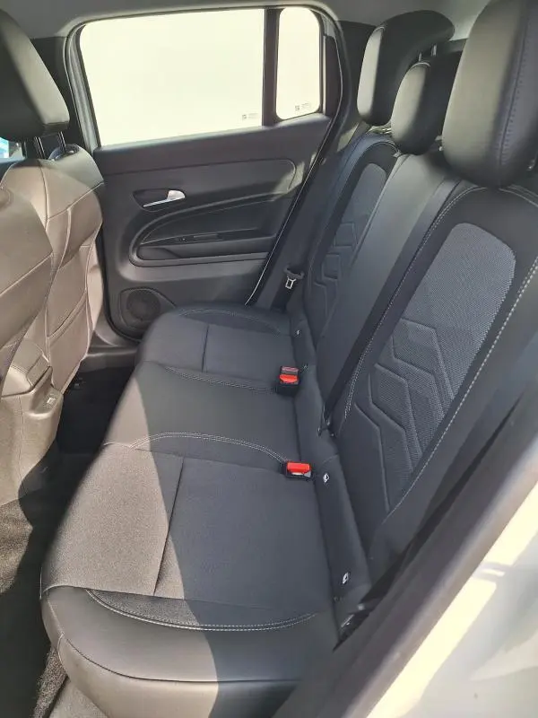 Vue intérieure côté droit des sièges arrière noirs du Jeep Avenger blanc 2025 avec ceinture et appuie-têtes visibles.