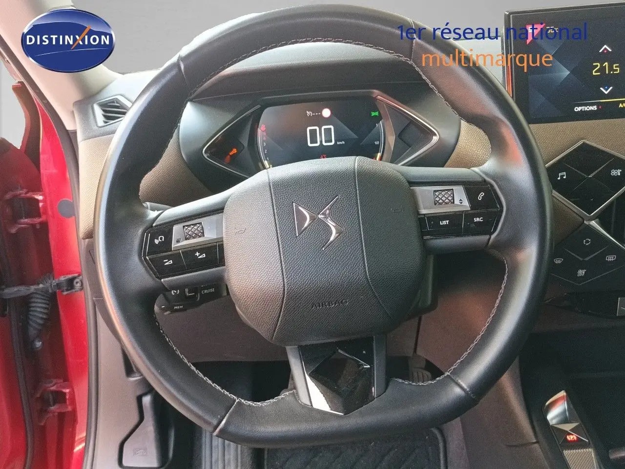 Vue intérieure centrée sur le volant cuir noir du DS3 Crossback rouge, avec tableau de bord numérique et écran tactile visible.