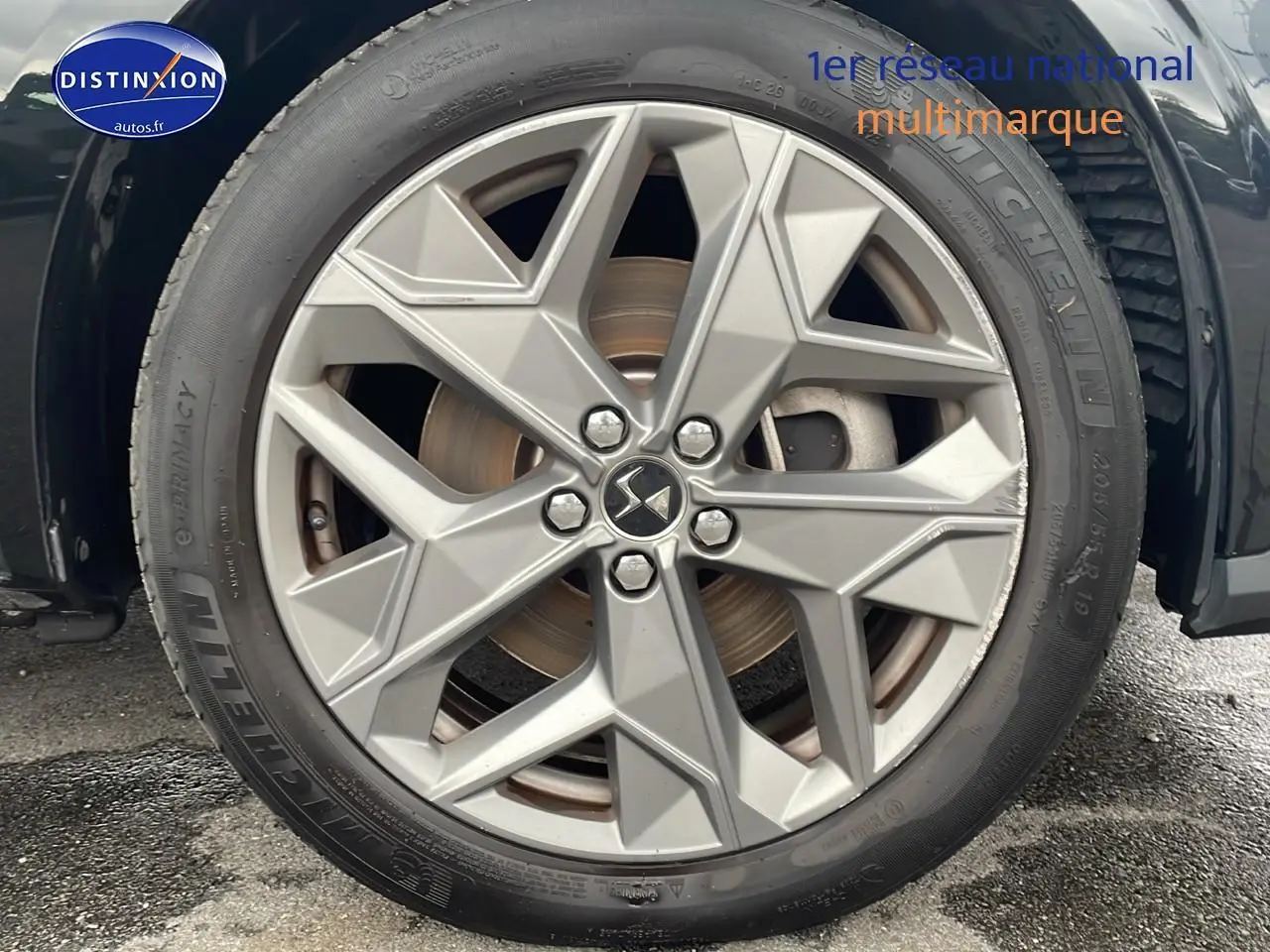 Gros plan sur la jante 19 pouces argentée du côté avant droit d'une DS4 E-tense 225 noire de 2023.