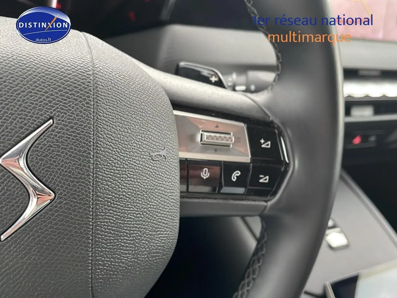 Gros plan sur le volant cuir noir du DS4 E-tense 225 avec commandes vocales et palettes au volant.