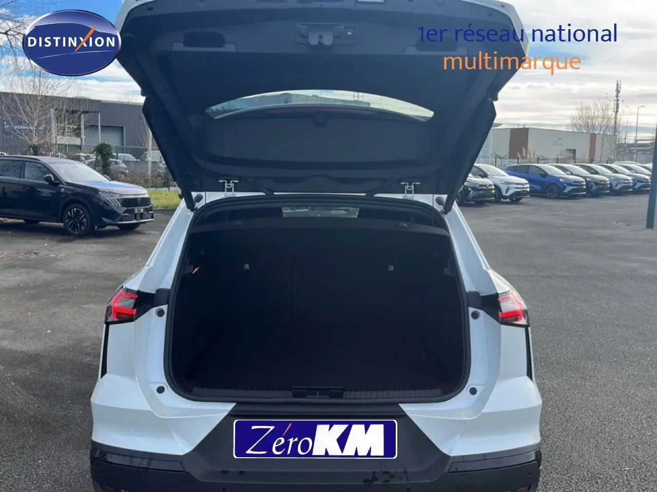 Vue arrière d'une Renault SYMBIOZ blanc nacré avec coffre ouvert, soulignant son espace de chargement généreux.