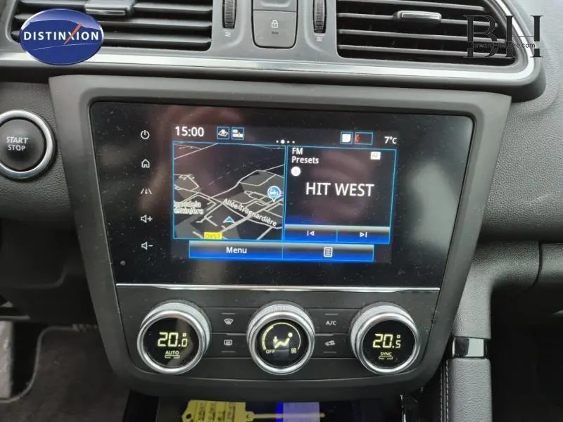 Vue rapprochée de l’écran tactile et de la console centrale du Renault Kadjar blanc, affichant la navigation et la radio FM.