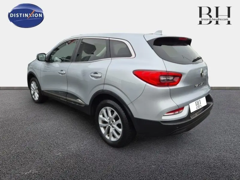 Vue 3/4 arrière droite du Renault Kadjar blanc avec jantes alu et vitres teintées sur fond neutre.