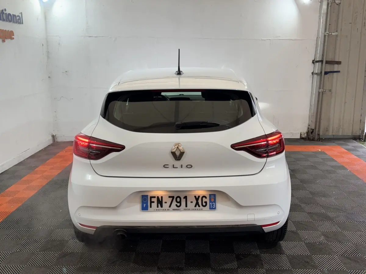 Vue arrière d'une Renault Clio blanche de 2020 avec feux LED et plaque d'immatriculation française visible.
