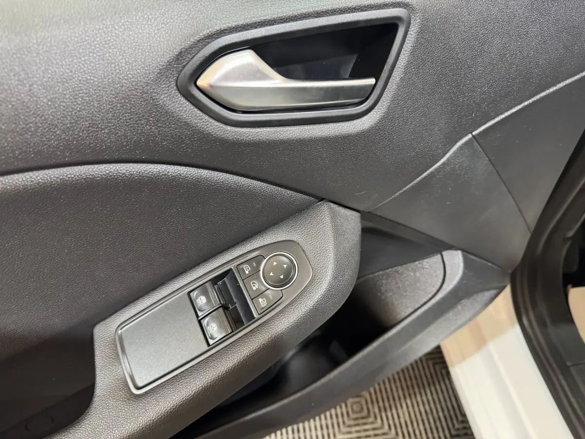 Détail de la porte avant gauche de la Renault Clio Business blanche, montrant les commandes de vitres et rétroviseurs.