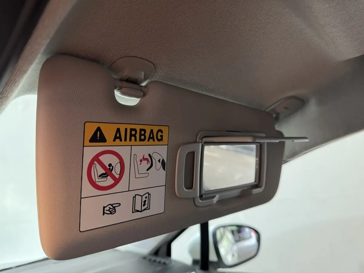 Vue intérieure du pare-soleil côté conducteur avec avertissement airbag dans une Renault Clio Business blanche de 2020.