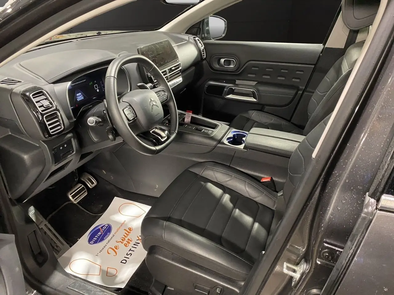 Intérieur avant droit du Citroën C5 Aircross gris platinium 2023 avec sièges noirs en cuir et tableau de bord moderne.