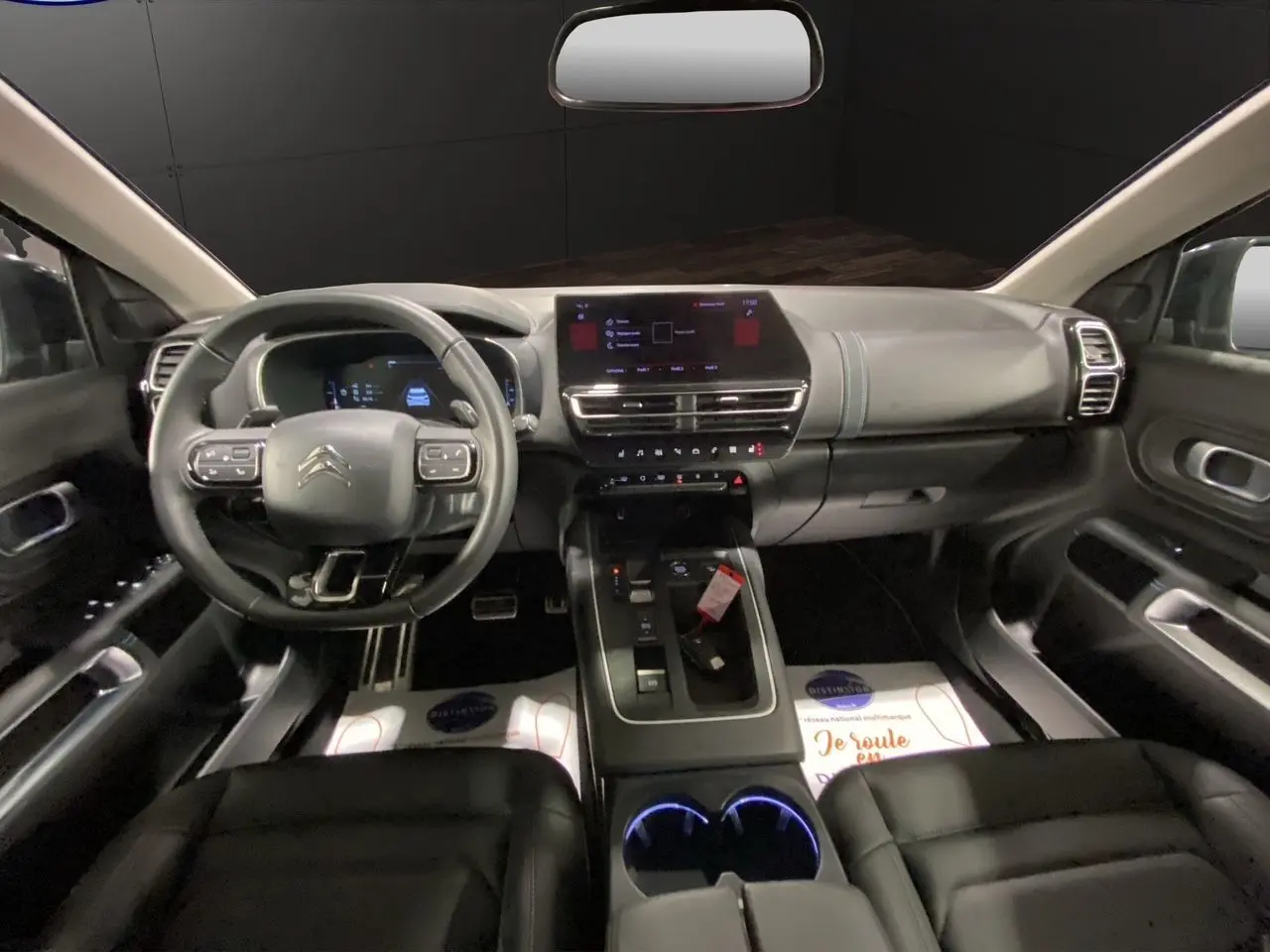 Vue intérieure avant du Citroën C5 Aircross 2023, tableau de bord moderne avec écran tactile et volant multifonction noir.