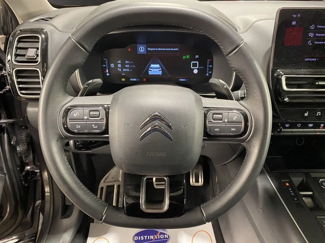 Vue rapprochée du volant cuir noir et du tableau de bord numérique du Citroën C5 Aircross 2023 gris platinium.