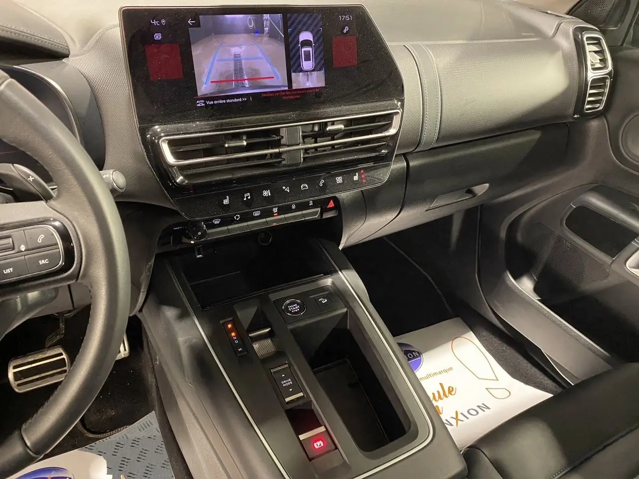 Intérieur noir du Citroën C5 Aircross 2023, vue du tableau de bord et console centrale avec écran tactile et caméra de recul affichée.