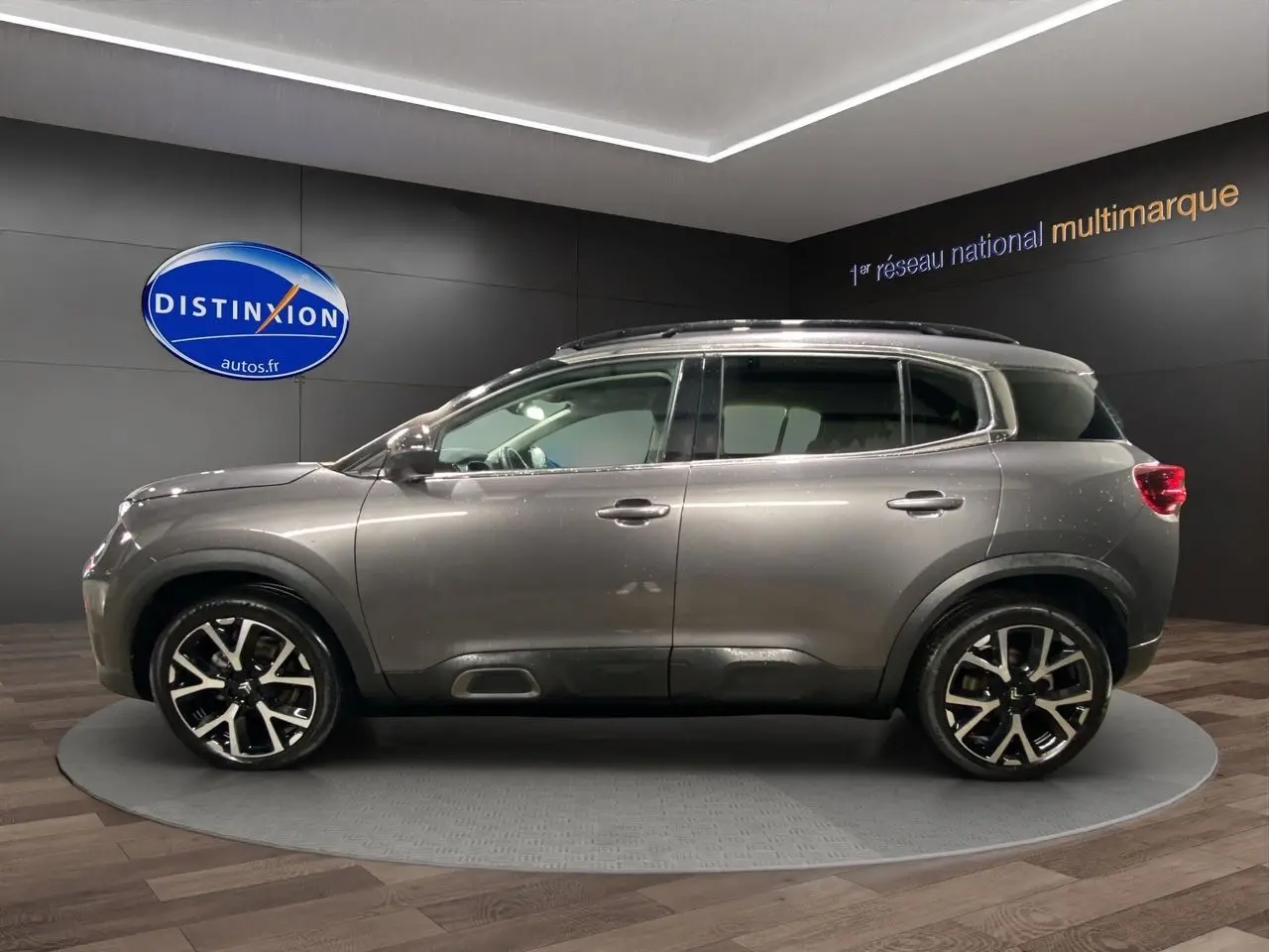 Profil latéral droit d'un Citroën C5 Aircross gris platinium 2023 avec jantes alliage noires et toit panoramique.