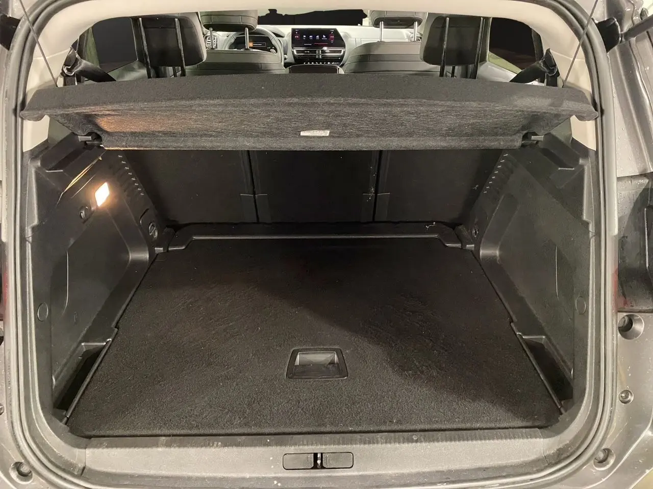 Coffre spacieux ouvert d'un Citroën C5 Aircross gris platinium, vue arrière avec banquette et tablette cache-bagages visibles.