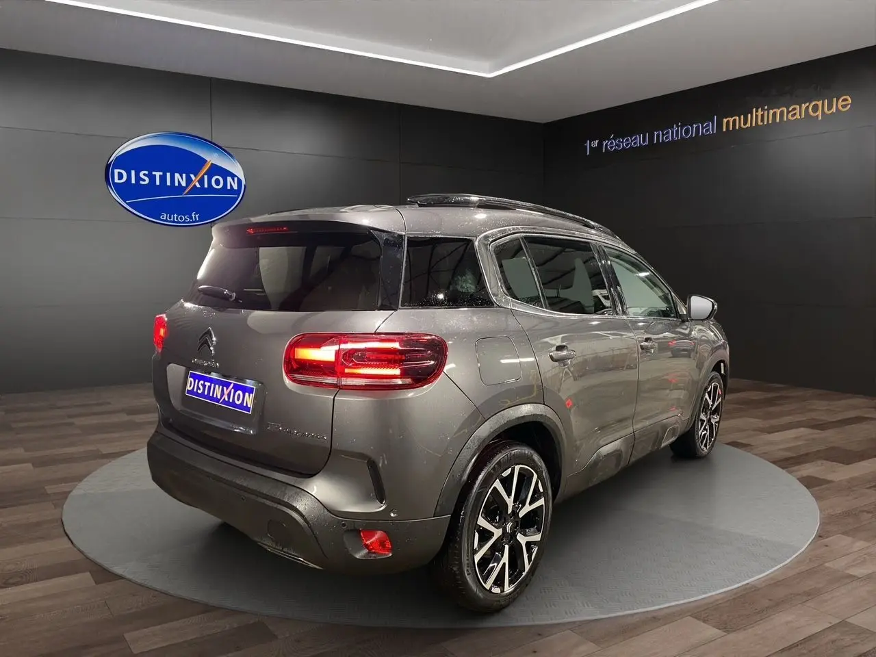 Vue 3/4 arrière droite d'un Citroën C5 Aircross gris platinium avec feux LED et jantes alliage noires.