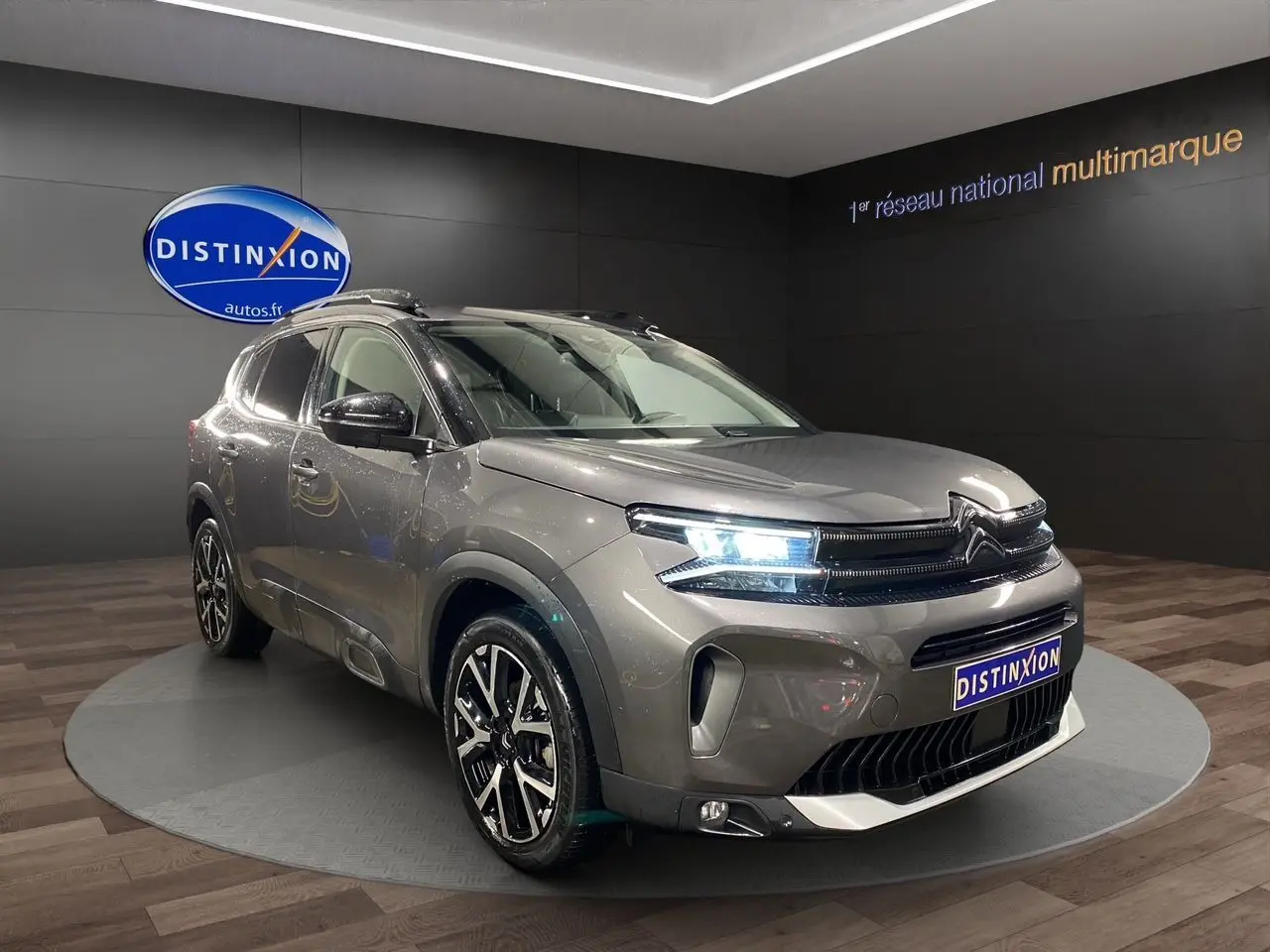 Vue 3/4 avant du Citroën C5 Aircross gris platinium avec feux LED allumés et jantes alliage noires.