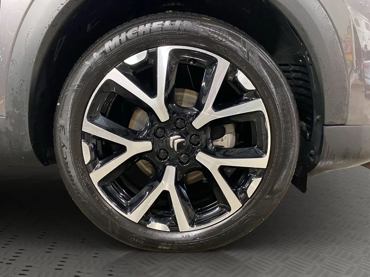 Gros plan sur la jante alliage bicolore noire et argentée d’un Citroën C5 Aircross gris platinium.