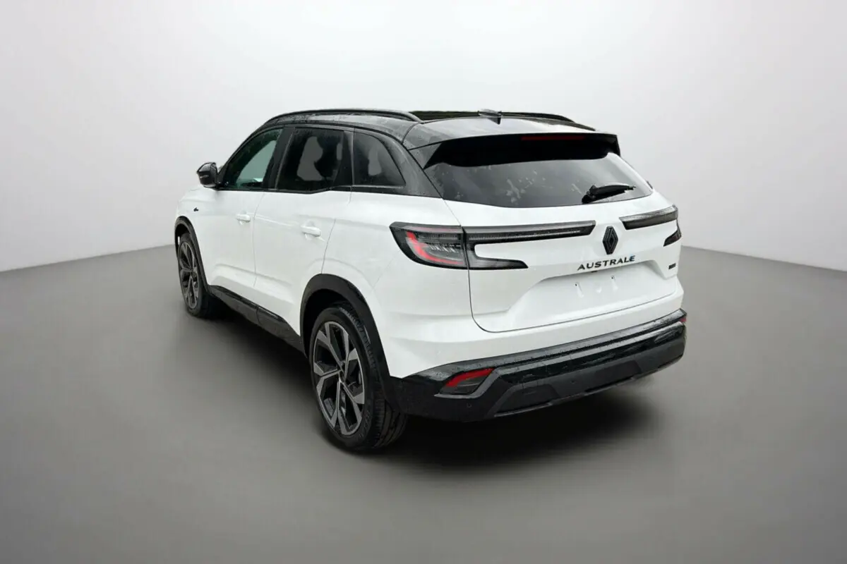 Vue 3/4 arrière droite d'un Renault Austral blanc nacré avec toit noir et feux arrière LED distinctifs.