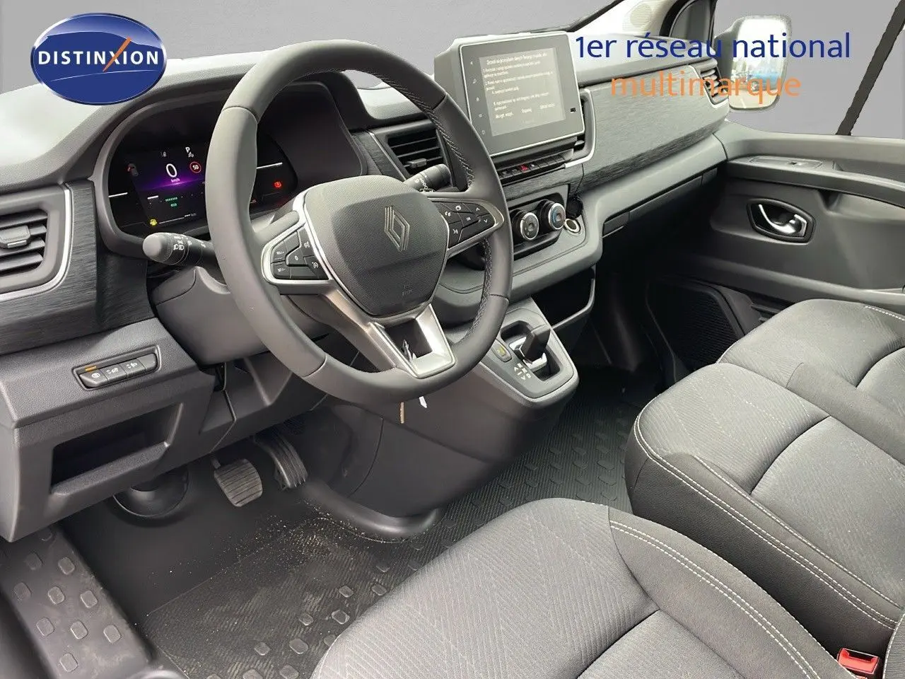 Intérieur du Renault Trafic Fourgon 2025 vu côté conducteur, tableau de bord moderne et sièges tissu noir.