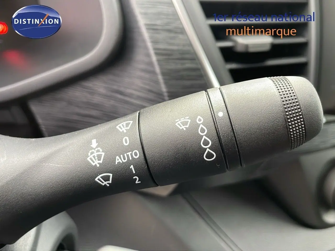 Gros plan sur la manette d'essuie-glace du Renault Trafic Fourgon blanc Glacier, montrant les réglages automatiques et manuels.