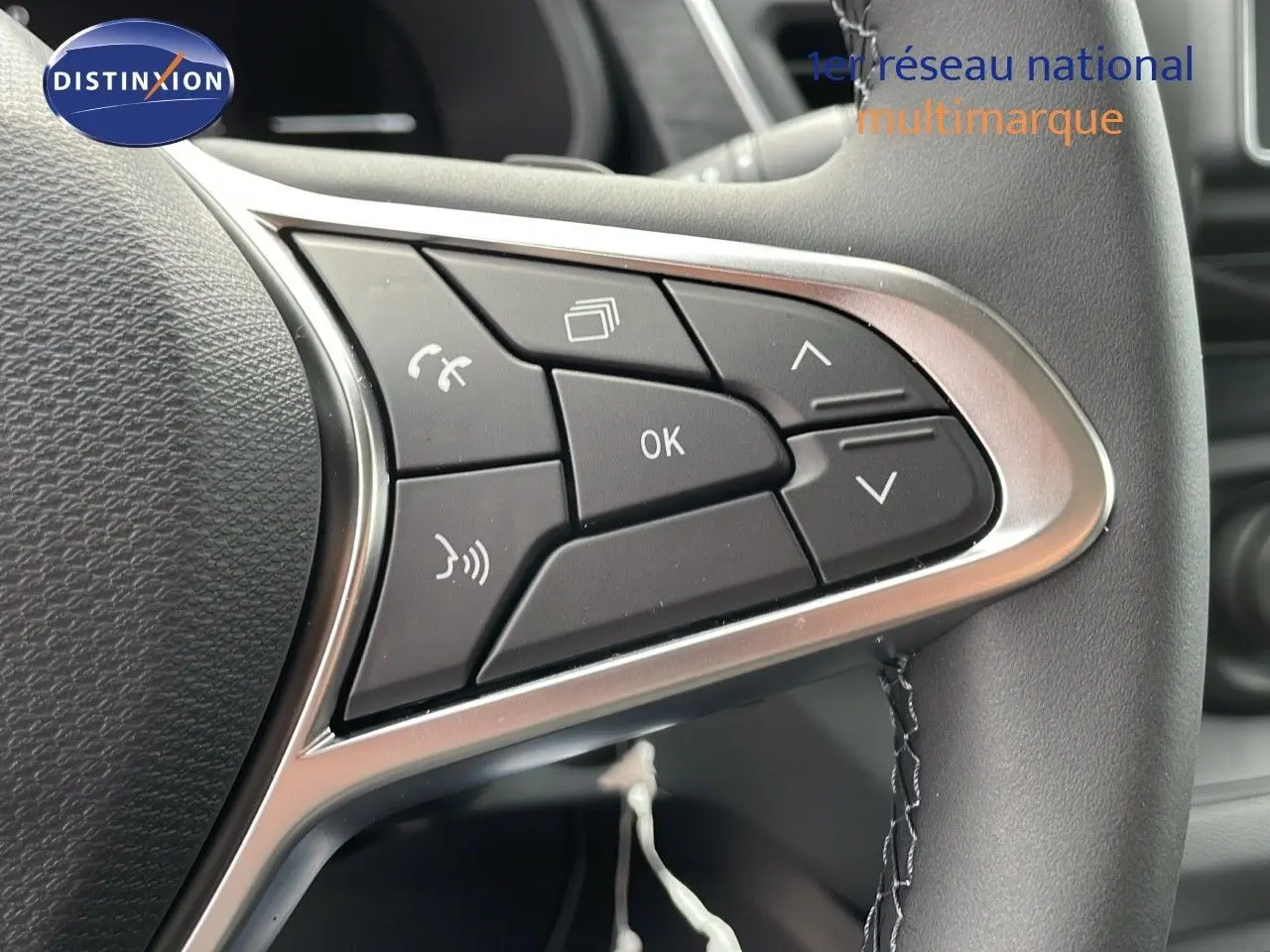 Gros plan sur les commandes multifonctions à droite du volant du Renault Trafic Fourgon blanc glacier 2025.