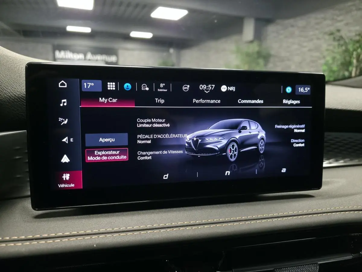 Écran tactile intérieur affichant une Alfa Romeo Tonale bleu en vue 3/4 avant avec détails des modes de conduite.