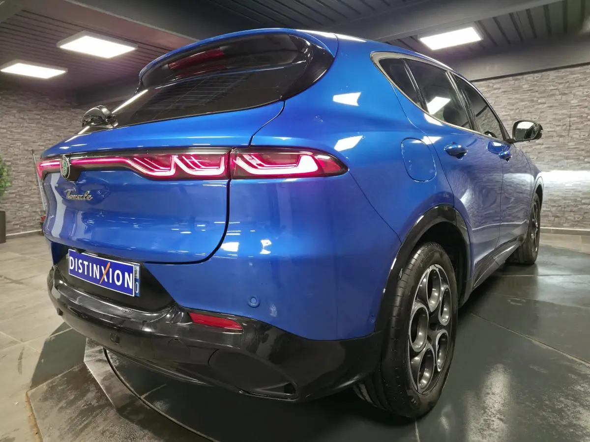 Vue 3/4 arrière droite de l'Alfa Romeo Tonale bleu métallisé avec feux arrière LED et jantes alliage 18 pouces.