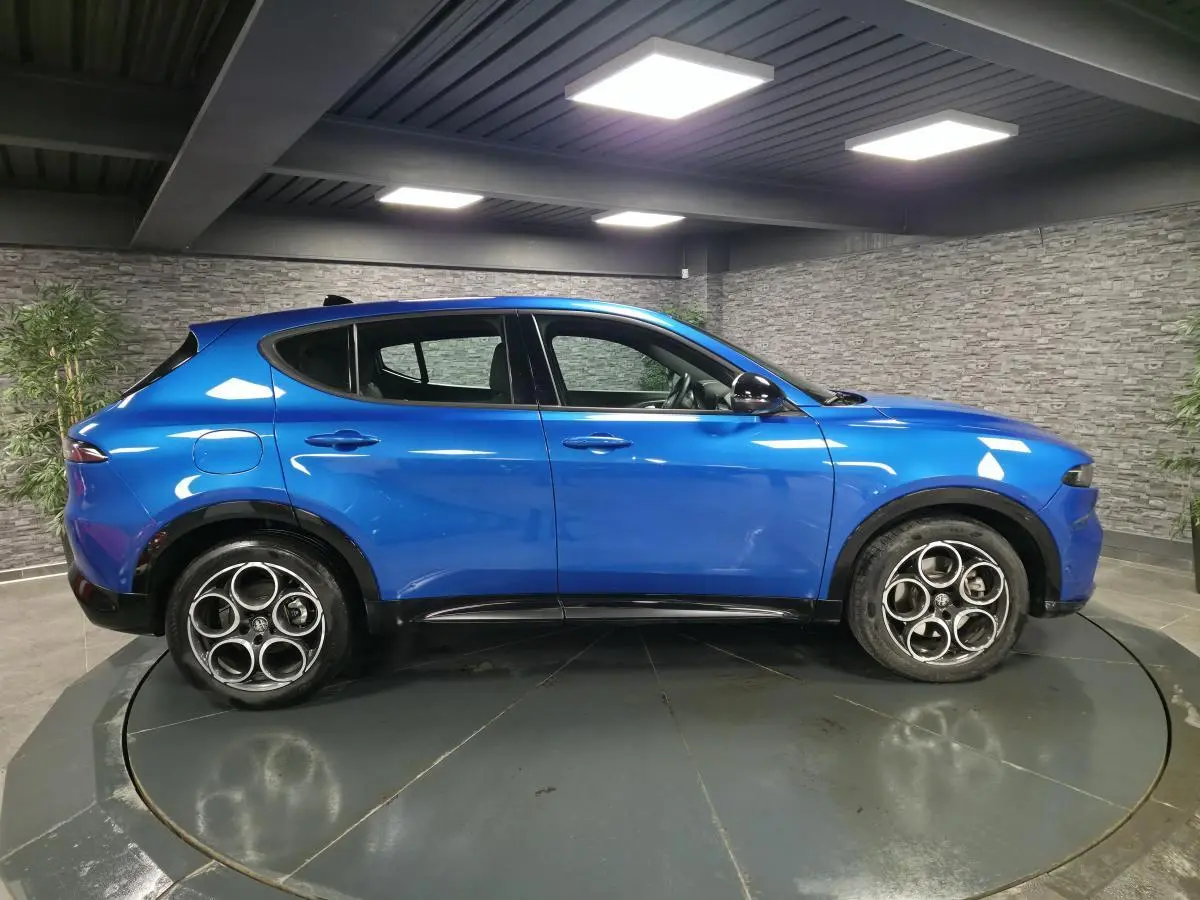 Vue de profil côté gauche d'une Alfa Romeo Tonale Sprint 2025 bleu métallisé avec jantes alliage distinctives.