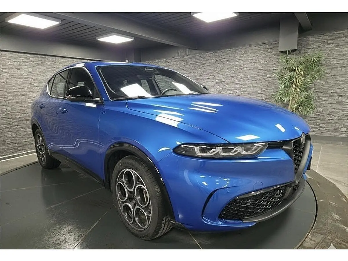 Vue 3/4 avant droite d'une Alfa Romeo Tonale Sprint 2025 bleu métallisé avec jantes alliage et calandre caractéristique.