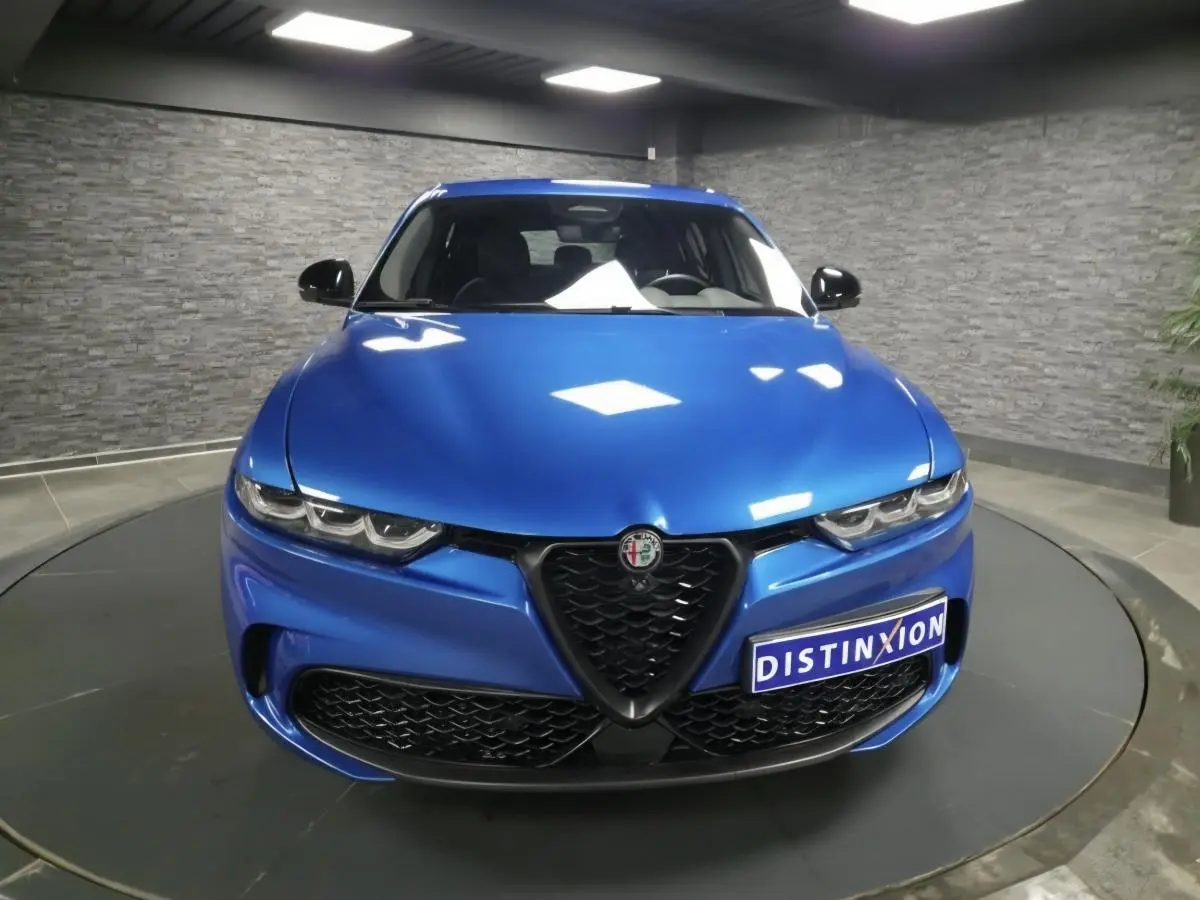 Vue frontale d'une Alfa Romeo Tonale Sprint 2025 bleu métallisé avec calandre noire et phares LED distinctifs.